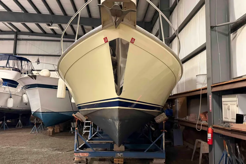 Slide: The Image of 2005 Mainship Pilot 34 boat stored indoors on a stand in a warehouse. - 2