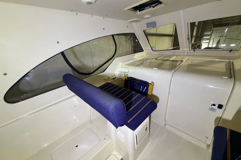 Slide: The Image of 2005 Mainship Pilot 34 interior with blue seating and large windows. - 20