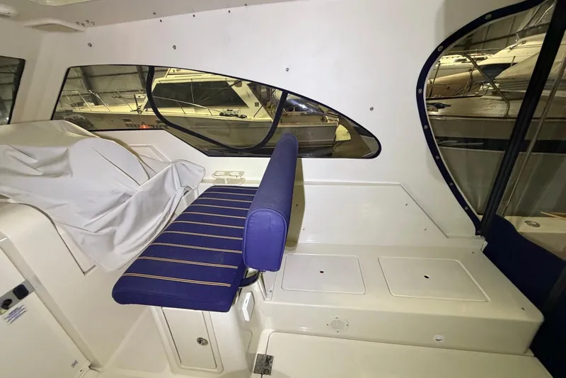Slide: The Image of Interior of a 2005 Mainship Pilot 34 boat with blue seating and large windows. - 21