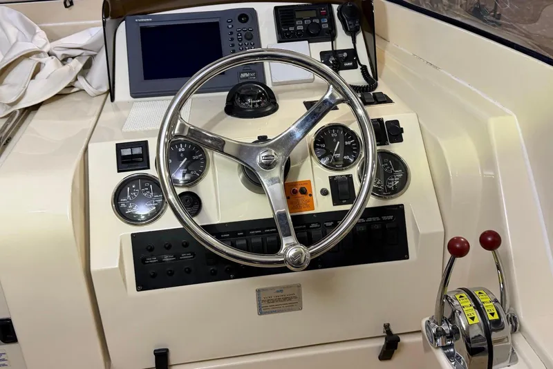 Slide: The Image of 2005 Mainship Pilot 34 helm with steering wheel, gauges, and navigation equipment. - 22