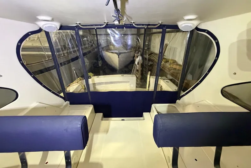 Slide: The Image of Interior view of 2005 Mainship Pilot 34 boat with blue seating and clear windows. - 23