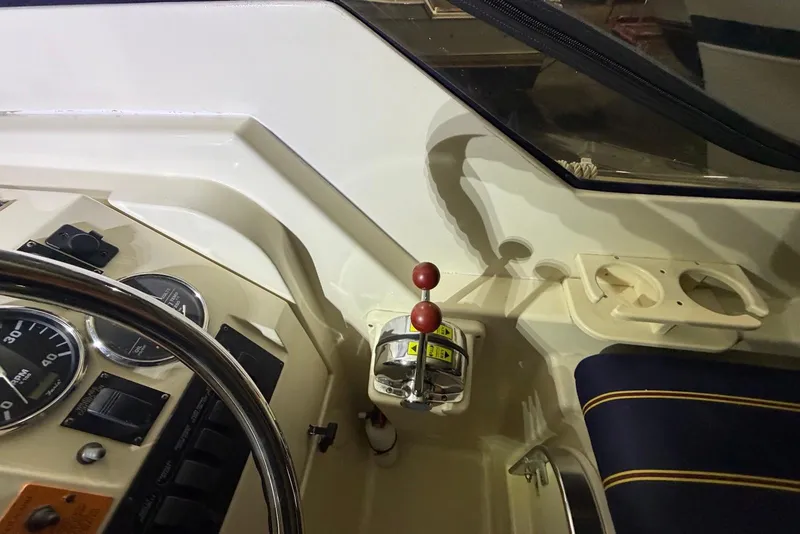 Slide: The Image of 2005 Mainship Pilot 34 helm with gauges, throttle, and cup holders. - 25