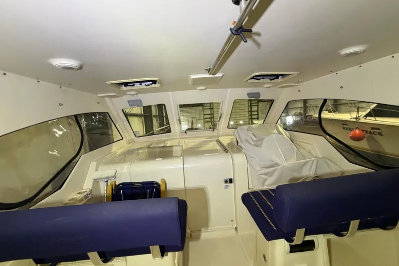 Slide: The Image of 2005 Mainship Pilot 34 interior with blue seating and covered helm station. - 26