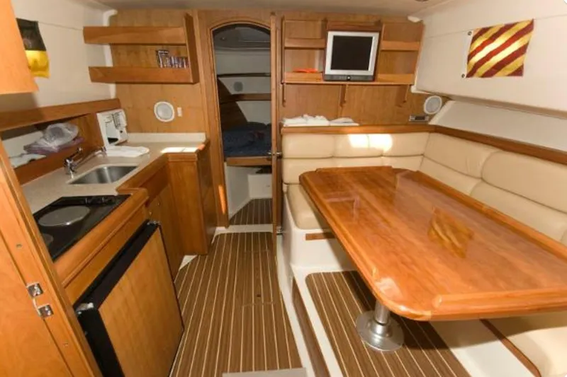 Slide: The Image of 2005 Mainship Pilot 34 interior with kitchenette, dining area, and cozy cabin space. - 27