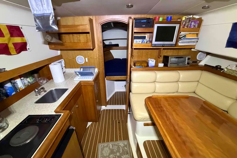 Slide: The Image of 2005 Mainship Pilot 34 interior with kitchenette, dining area, and cozy cabin space. - 29