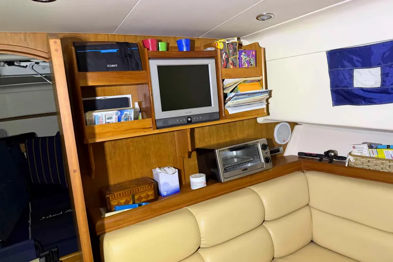 Slide: The Image of Interior of a 2005 Mainship Pilot 34 boat with TV, shelves, and seating area. - 32