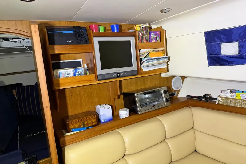 Slide: The Image of Interior of a 2005 Mainship Pilot 34 boat with TV, shelves, and seating area. - 34