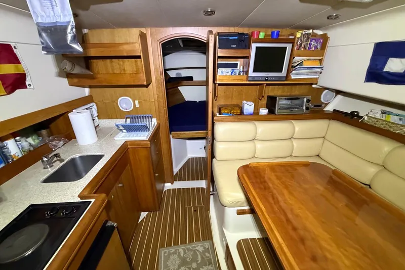 Slide: The Image of Interior of 2005 Mainship Pilot 34 boat with kitchen, seating, and entertainment area. - 36