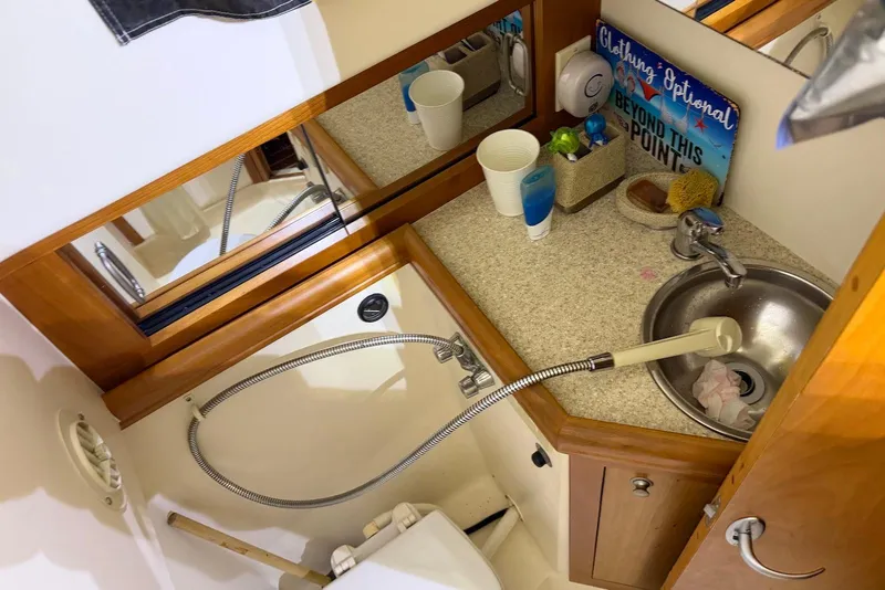 Slide: The Image of 2005 Mainship Pilot 34 boat bathroom with sink, mirror, and countertop accessories. - 40