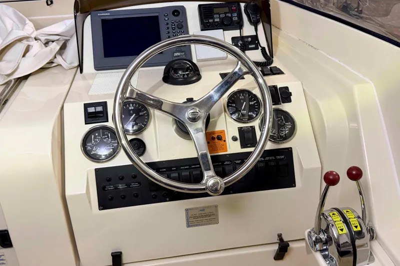 Slide: The Image of 2005 Mainship Pilot 34 helm with steering wheel, gauges, and navigation controls. - 9