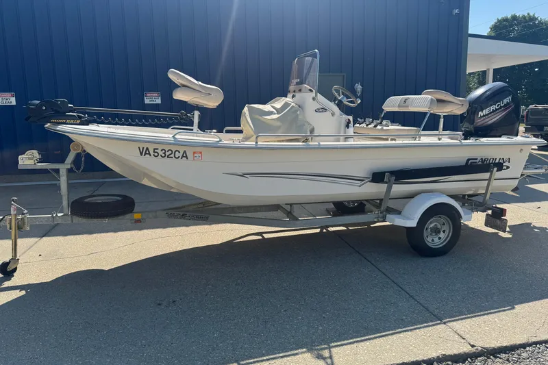 Slide: The Image of 2016 Carolina Skiff 18 JVX CC boat on trailer, parked outdoors. - 1
