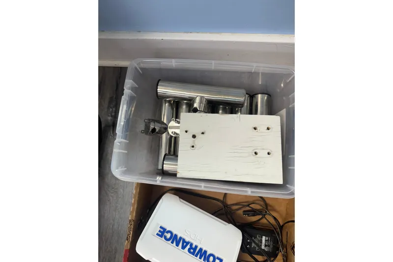 Slide: The Image of Plastic container with metal rods and a white panel, next to a Lowrance device. - 16