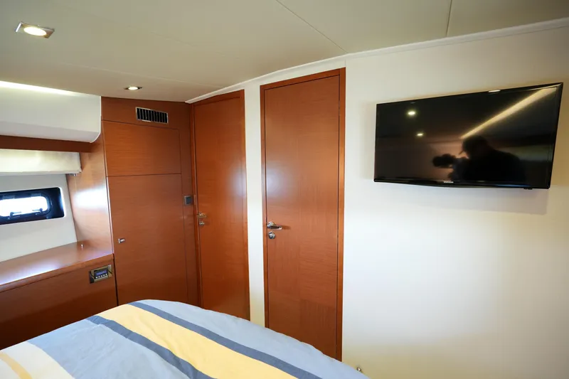 Slide: The Image of Luxurious cabin interior of 2015 Prestige 500S yacht with wood paneling and mounted TV. - 57