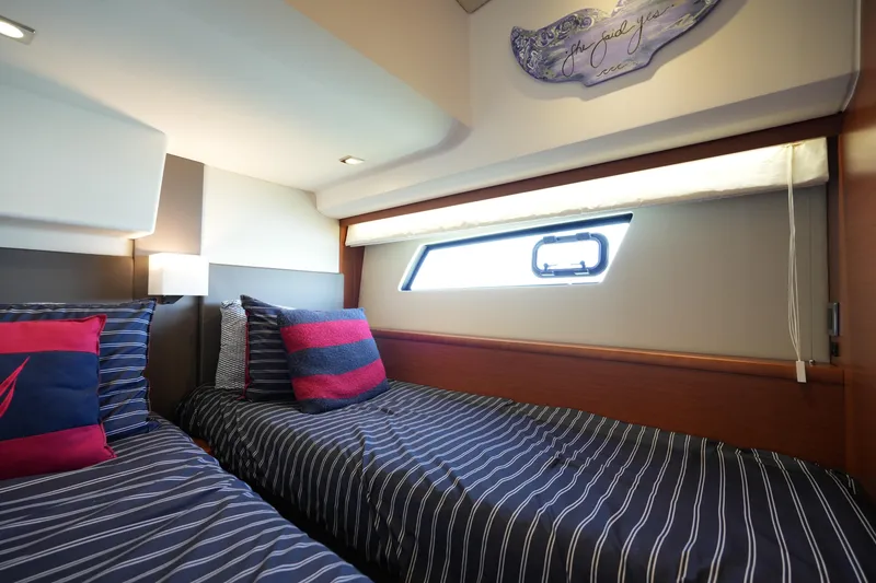 Slide: The Image of Luxurious twin cabin interior on a 2015 Prestige 500S yacht with striped bedding. - 61