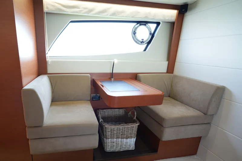Slide: The Image of Luxurious seating area in a 2015 Prestige 500S yacht with elegant table and window view. - 69