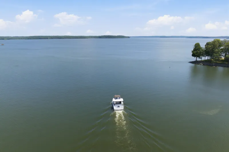 Slide: The Image of 1997 Sea Ray 370 Aft Cabin cruising on a serene lake under a clear blue sky. - 11