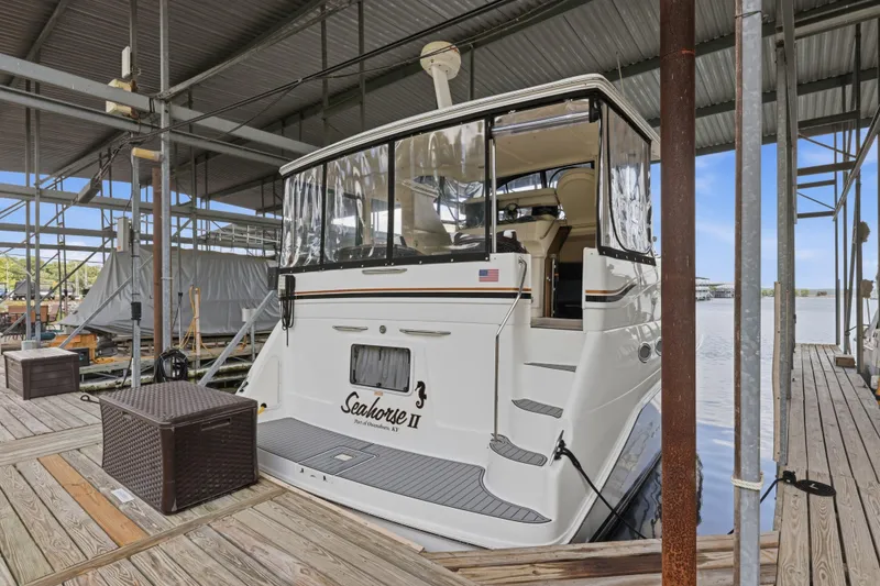 Slide: The Image of 1997 Sea Ray 370 Aft Cabin yacht docked in a marina, rear view. - 15