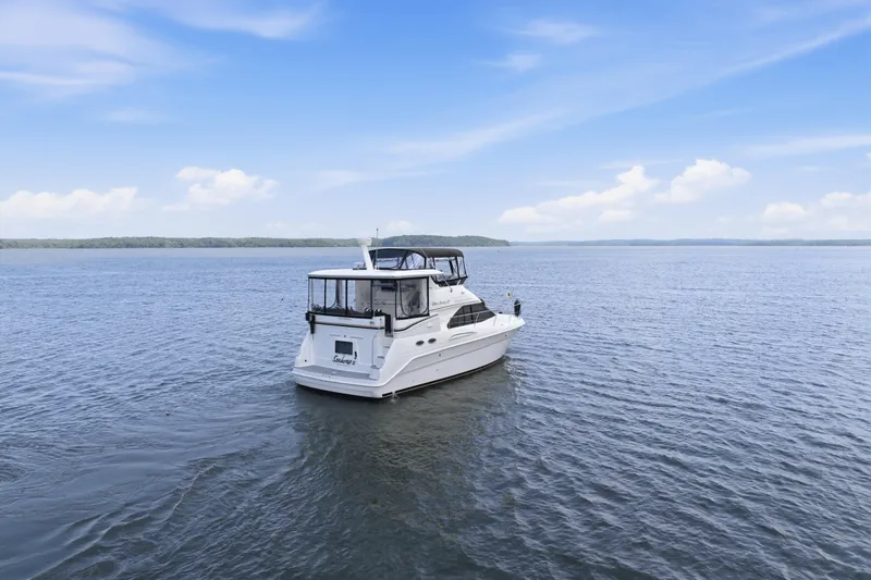 Slide: The Image of 1997 Sea Ray 370 Aft Cabin yacht on open water under a clear blue sky. - 2