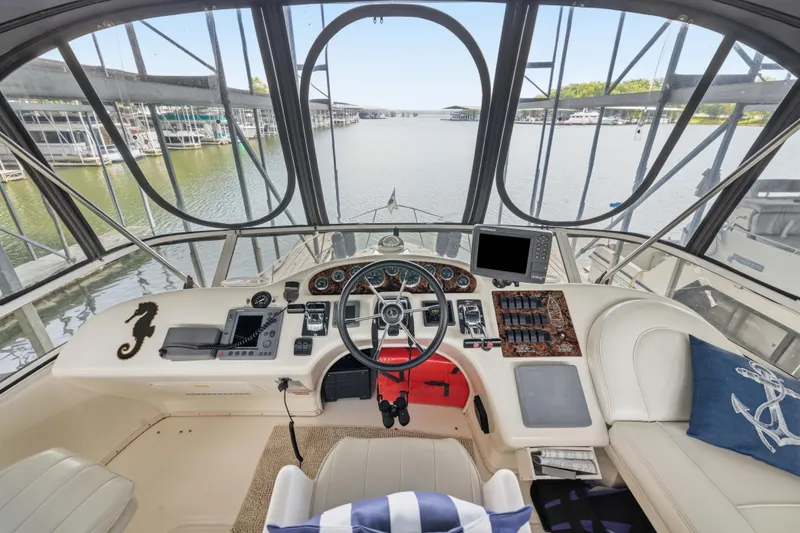 Slide: The Image of 1997 Sea Ray 370 Aft Cabin helm with steering wheel, controls, and marina view. - 20