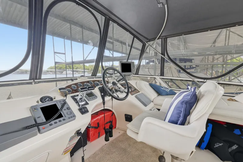 Slide: The Image of 1997 Sea Ray 370 Aft Cabin helm with steering wheel, controls, and cushioned seating. - 22