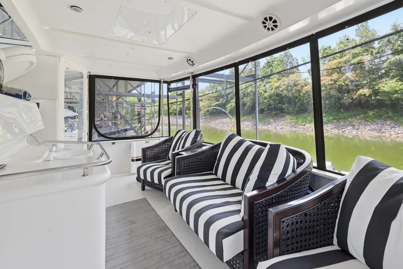Slide: The Image of 1997 Sea Ray 370 Aft Cabin interior with striped seating and scenic waterway view. - 24
