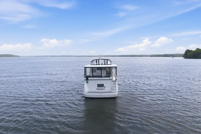 Slide: The Image of 1997 Sea Ray 370 Aft Cabin yacht on a serene lake under a clear blue sky. - 3