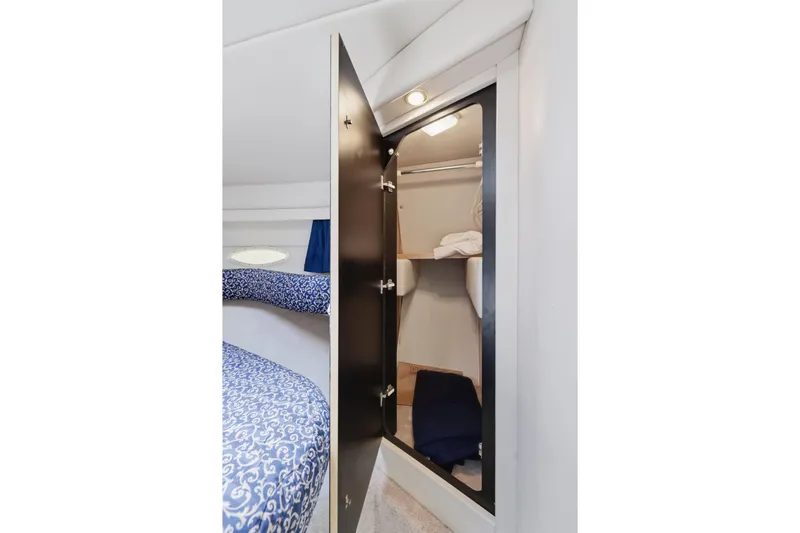 Slide: The Image of 1997 Sea Ray 370 Aft Cabin interior closet with open door and bedding. - 35