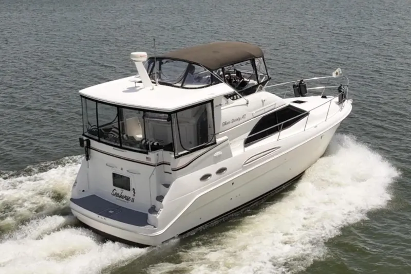 Slide: The Image of 1997 Sea Ray 370 Aft Cabin cruising on a serene lake under a partly cloudy sky. - 9