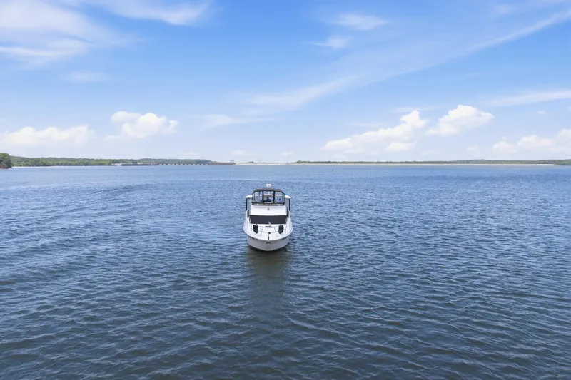 Slide: The Image of 1997 Sea Ray 370 Aft Cabin yacht on open water under a clear blue sky. - 7
