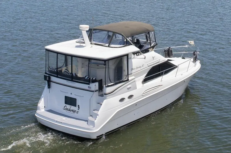 Slide: The Image of 1997 Sea Ray 370 Aft Cabin cruising on a calm lake under a clear blue sky. - 10