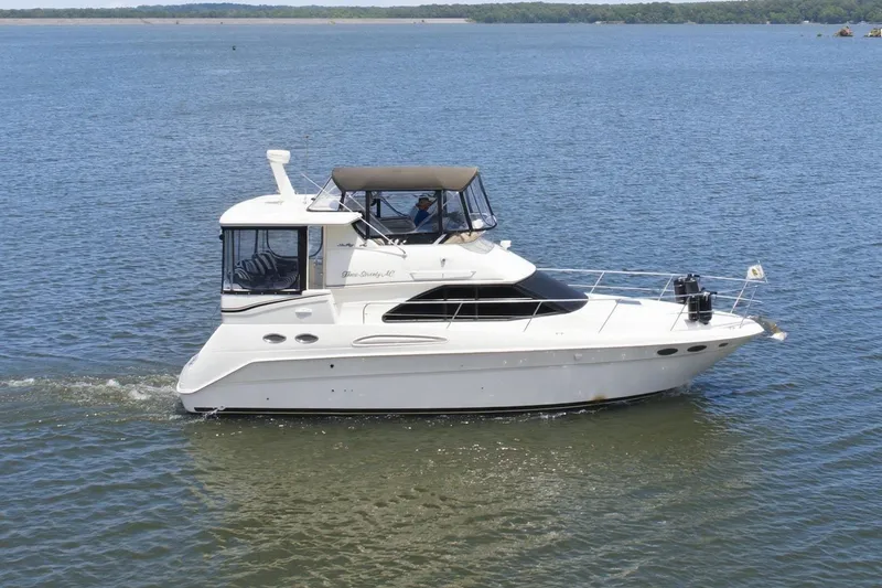 Slide: The Image of 1997 Sea Ray 370 Aft Cabin cruising on a calm lake under a clear blue sky. - 1