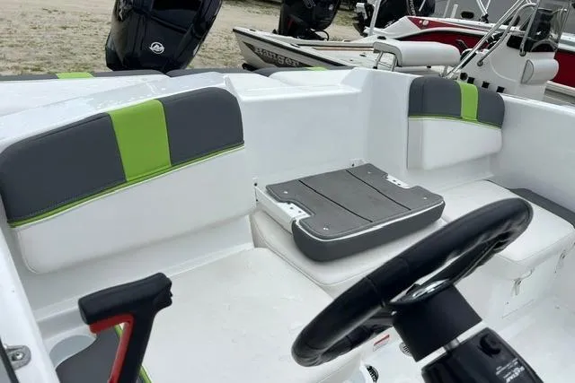Slide: The Image of 2022 Tahoe T16 boat interior with gray and green seating, steering wheel, and deck. - 3