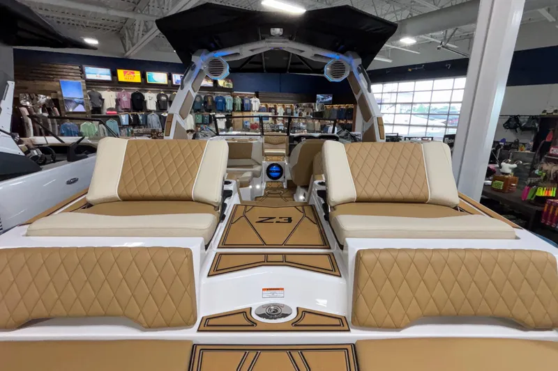 Slide: The Image of 2026 Tigé Z3 boat interior with tan diamond-stitched seats in a showroom. - 11