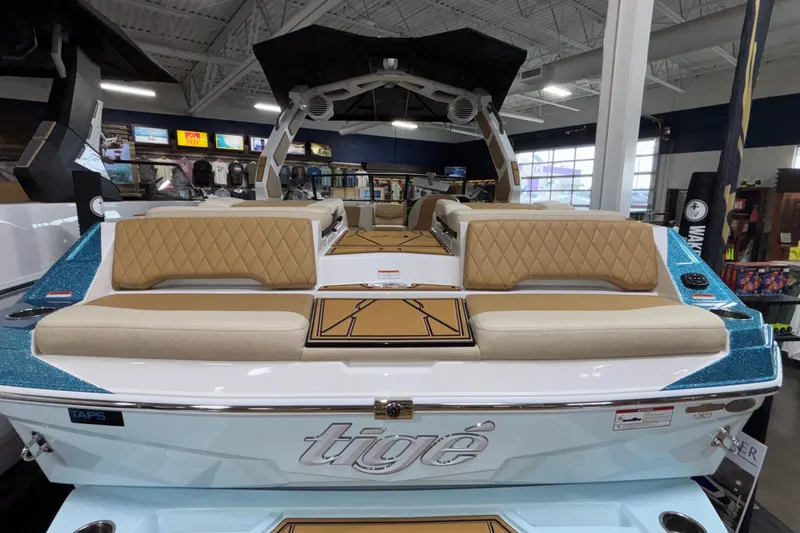 Slide: The Image of 2026 Tigé Z3 boat interior with tan diamond-stitched seating in a showroom. - 4