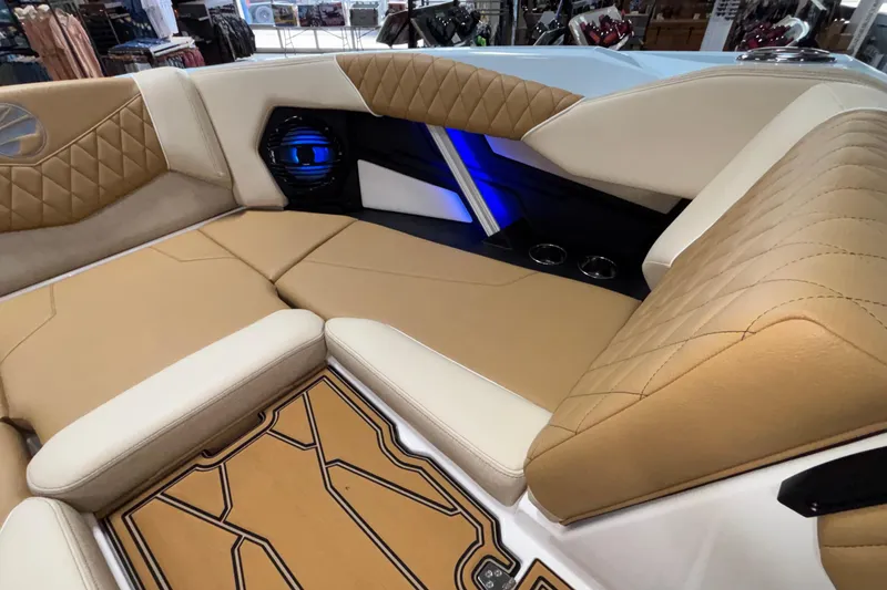 Slide: The Image of 2026 Tigé Z3 boat interior with tan and white upholstery, blue accent lighting, and cup holders. - 50