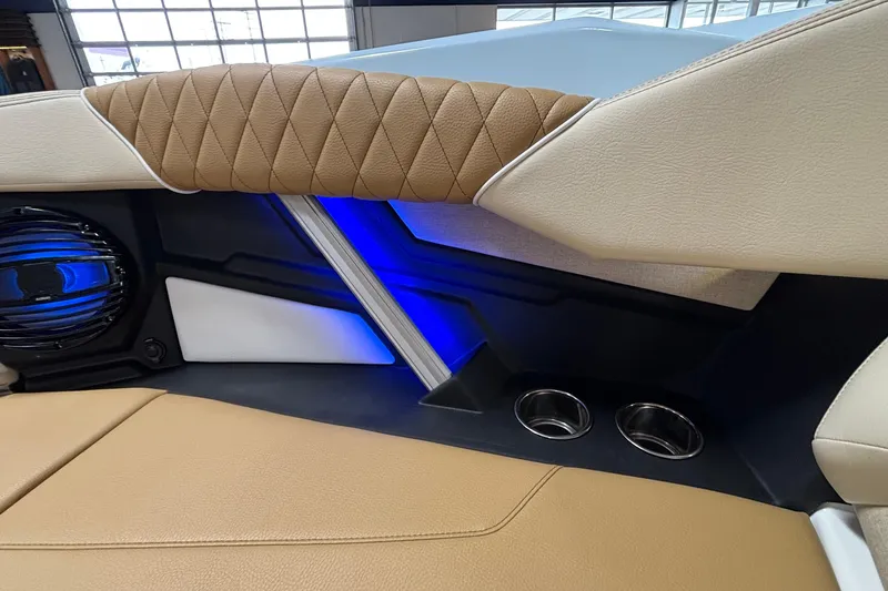 Slide: The Image of 2026 Tigé Z3 boat interior with tan upholstery, blue LED lighting, and cup holders. - 56