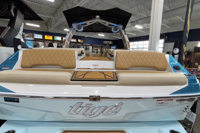 Slide: The Image of 2026 Tigé Z3 boat interior with beige seating and blue accents in showroom. - 8
