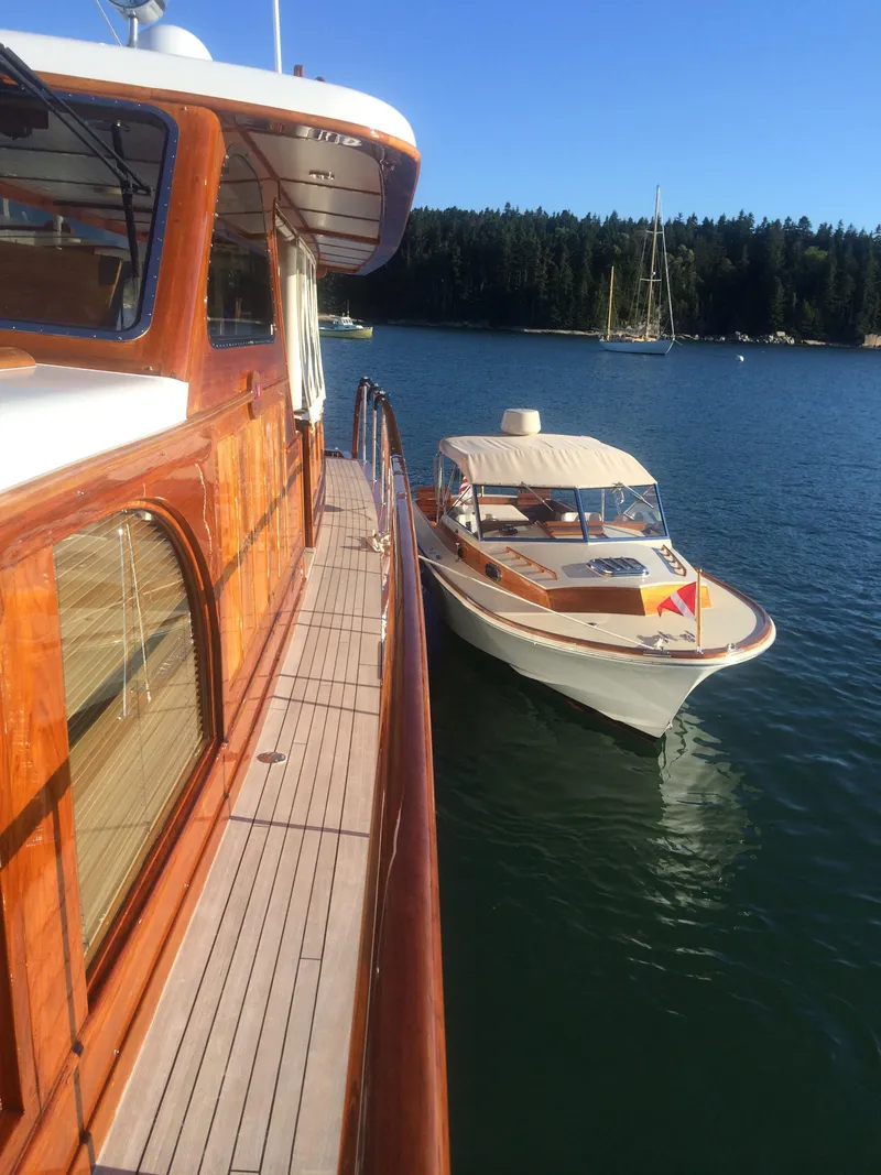 Slide: The Image of 2014 Hunt Yachts Surfhunter 25 on calm water beside wooden boat. - 12