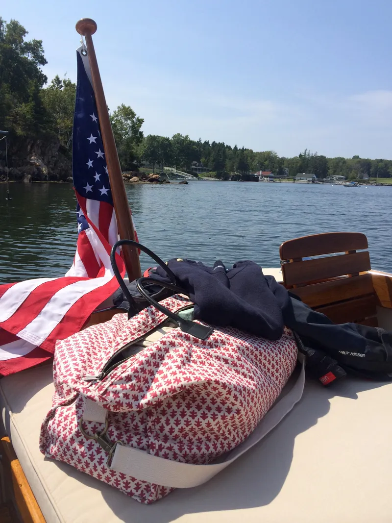 Slide: The Image of 2014 Hunt Yachts Surfhunter 25 with American flag on a lake. - 14