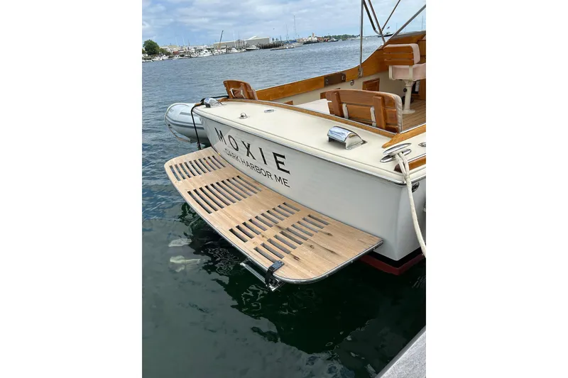 Slide: The Image of 2014 Hunt Yachts Surfhunter 25 docked, featuring a wooden swim platform and elegant design. - 57