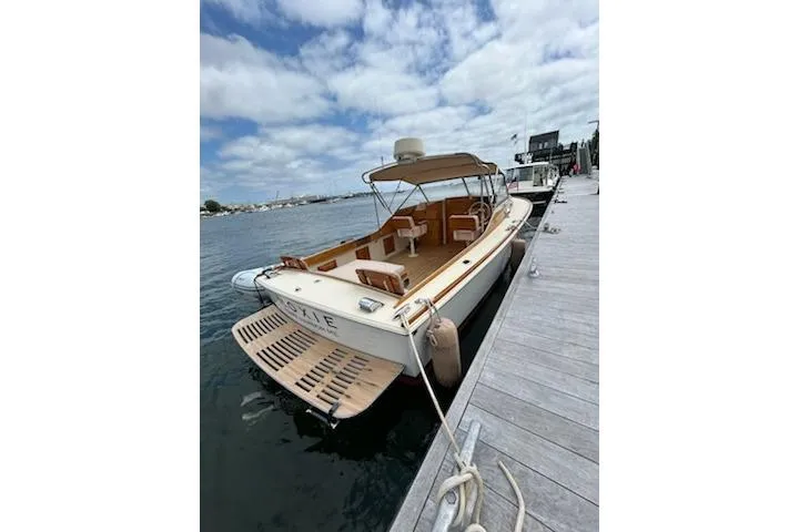 Slide: The Image of 2014 Hunt Yachts Surfhunter 25 docked, featuring a spacious deck and canopy. - 58