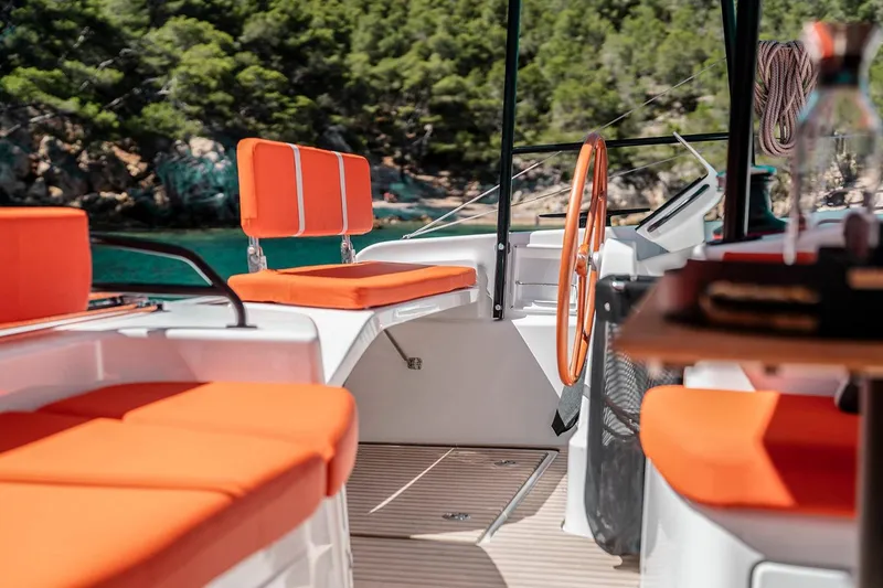 Slide: The Image of Manufacturer Provided Image: 2026 Excess 13 yacht interior with vibrant orange seating and scenic ocean backdrop. - 3