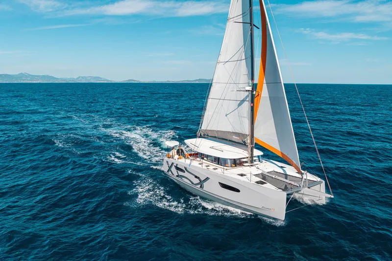 Slide: The Image of Sailing catamaran Excess 13, 2026 model, cruising on open sea under clear skies. - 7
