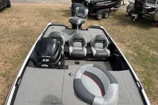 Slide: The Image of 2013 Nitro Z-6 boat interior with seating and motor, parked on grass. - 6