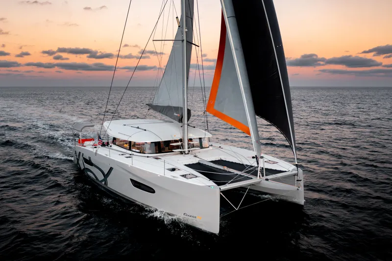 Slide: The Image of Sailing catamaran Excess 14, 2026 model, cruising at sunset on open sea. - 11