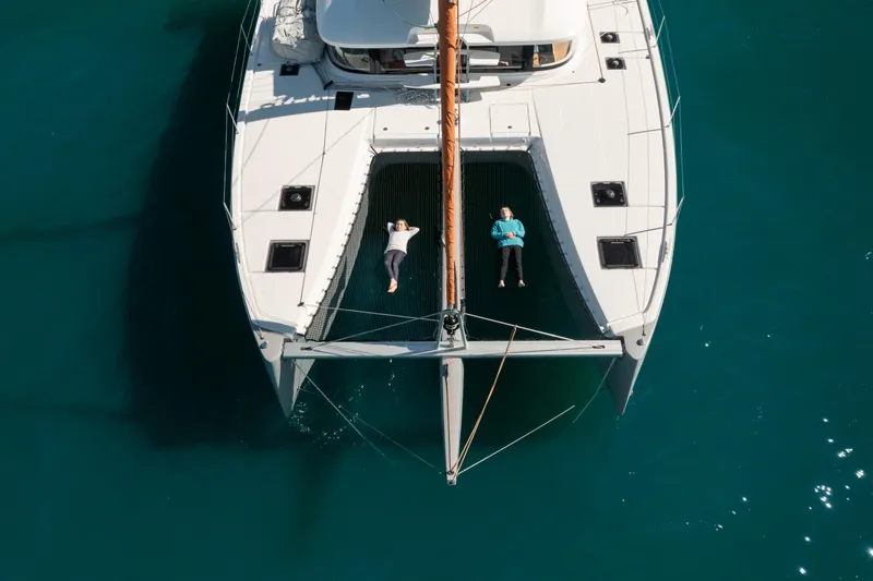 Slide: The Image of Aerial view of 2026 Excess 14 catamaran with two people relaxing on deck. - 19