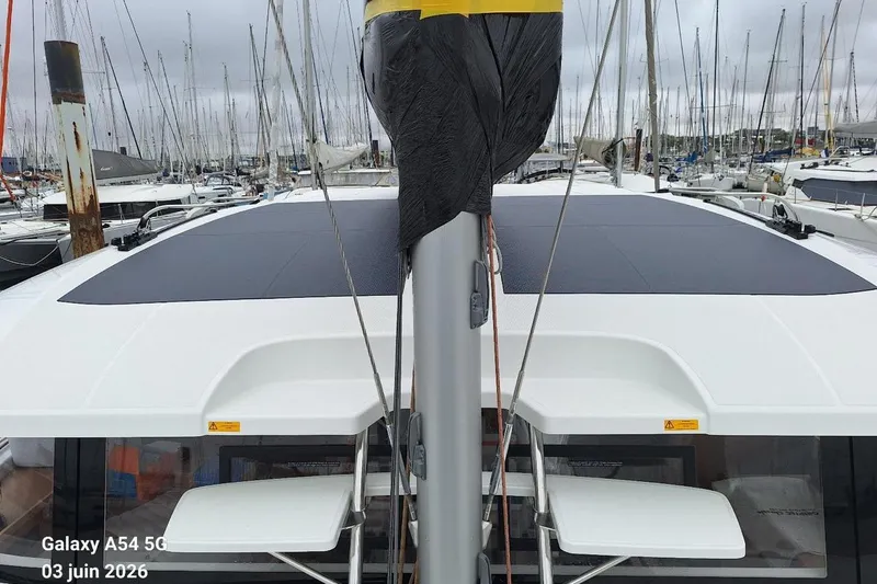 Slide: The Image of Sailboat Excess 14, 2026 model, docked in a marina with overcast skies. - 2