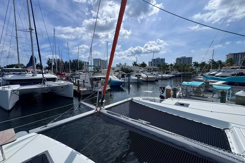 Slide: The Image of Marina view with 2026 Excess 14 catamaran, surrounded by boats under a partly cloudy sky. - 46