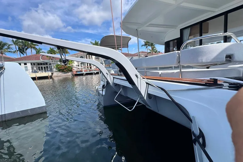 Slide: The Image of Modern Excess 14 catamaran docked by waterfront homes, 2026 model. - 43