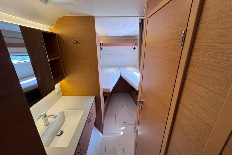 Slide: The Image of Interior of 2026 Excess 14 yacht featuring a compact cabin with twin beds and a sink. - 61